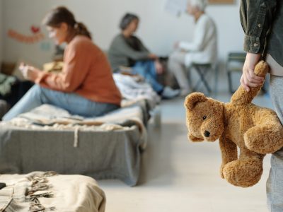 Brown teddybear in hand of child